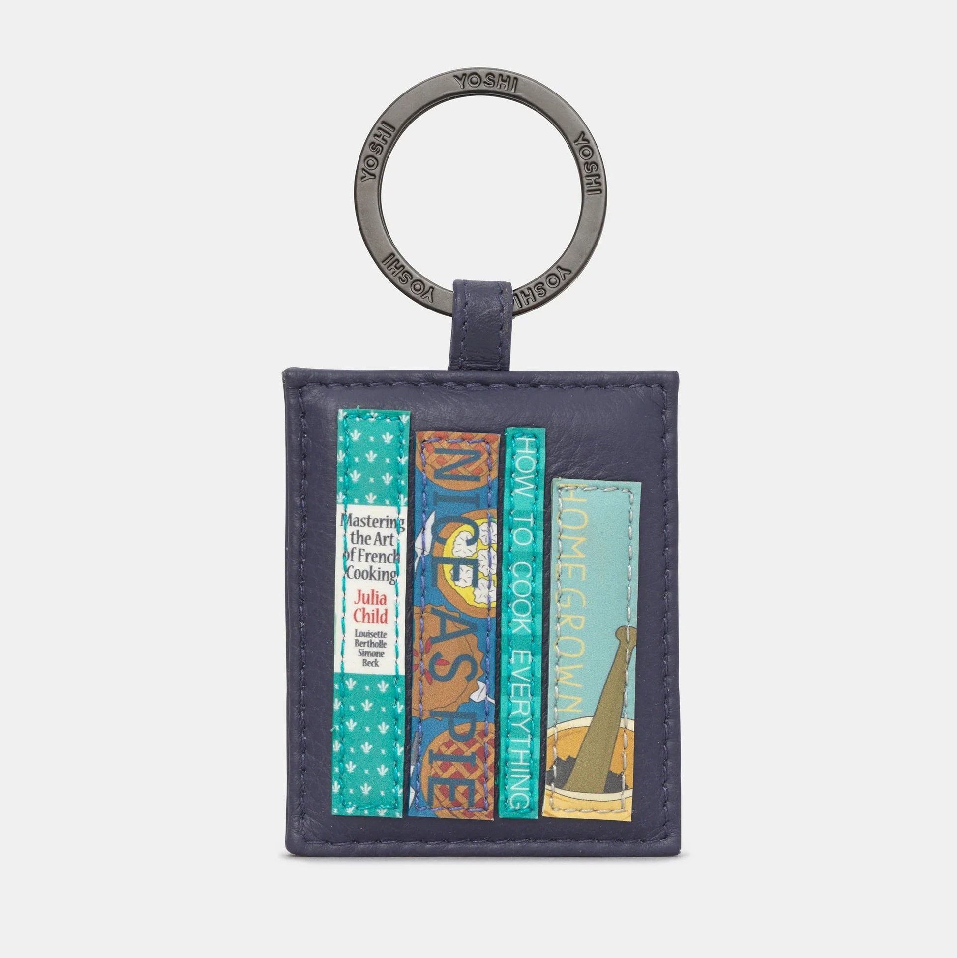 Front view of Cook Bookworm Library Leather Keyring with cookbook appliques on navy leather background.