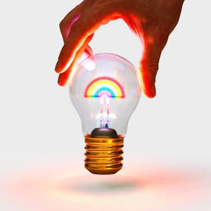 Hand holding glowing rainbow lightbulb over white backdrop – quirky LED rechargeable light