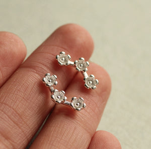 Close-up of Daisy Chain Sterling Silver Stud Earrings resting on a hand.