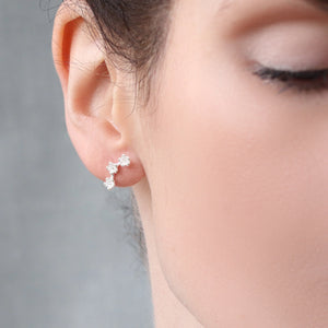 Model wearing delicate sterling silver flower earrings.