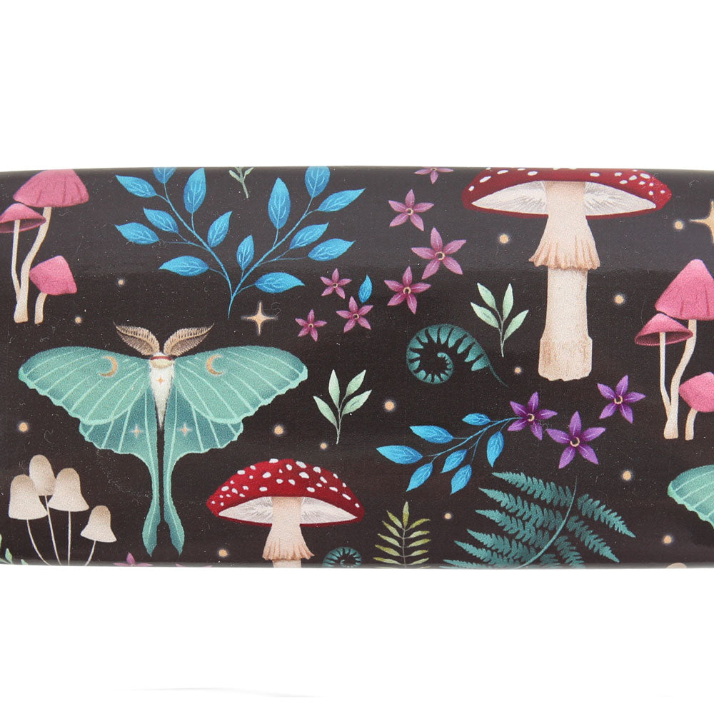 Close-up of Dark Forest print with mint-green moths, red toadstools, ferns and tiny stars on a deep black background.