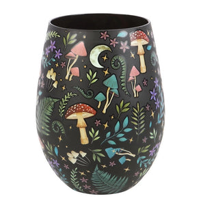 Dark Forest Print Stemless Wine Glass styled on wooden board with candlelight and woodland background.