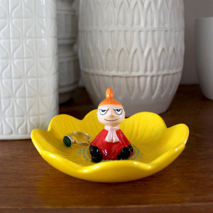 Moomin Little My ring dish featuring a yellow flower-shaped porcelain tray with a seated Little My figurine in the centre, holding a ring.