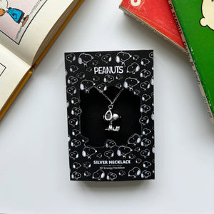 The Peanuts Snoopy necklace in its original black packaging, decorated with Snoopy illustrations.