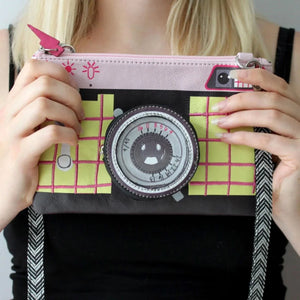 Person holding the Pix Camera Makeup Bag, displaying its playful camera-inspired design.