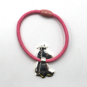 The back of the Snorkmaiden charm on the pink elastic hairband, displaying the metallic finish and engraved branding.