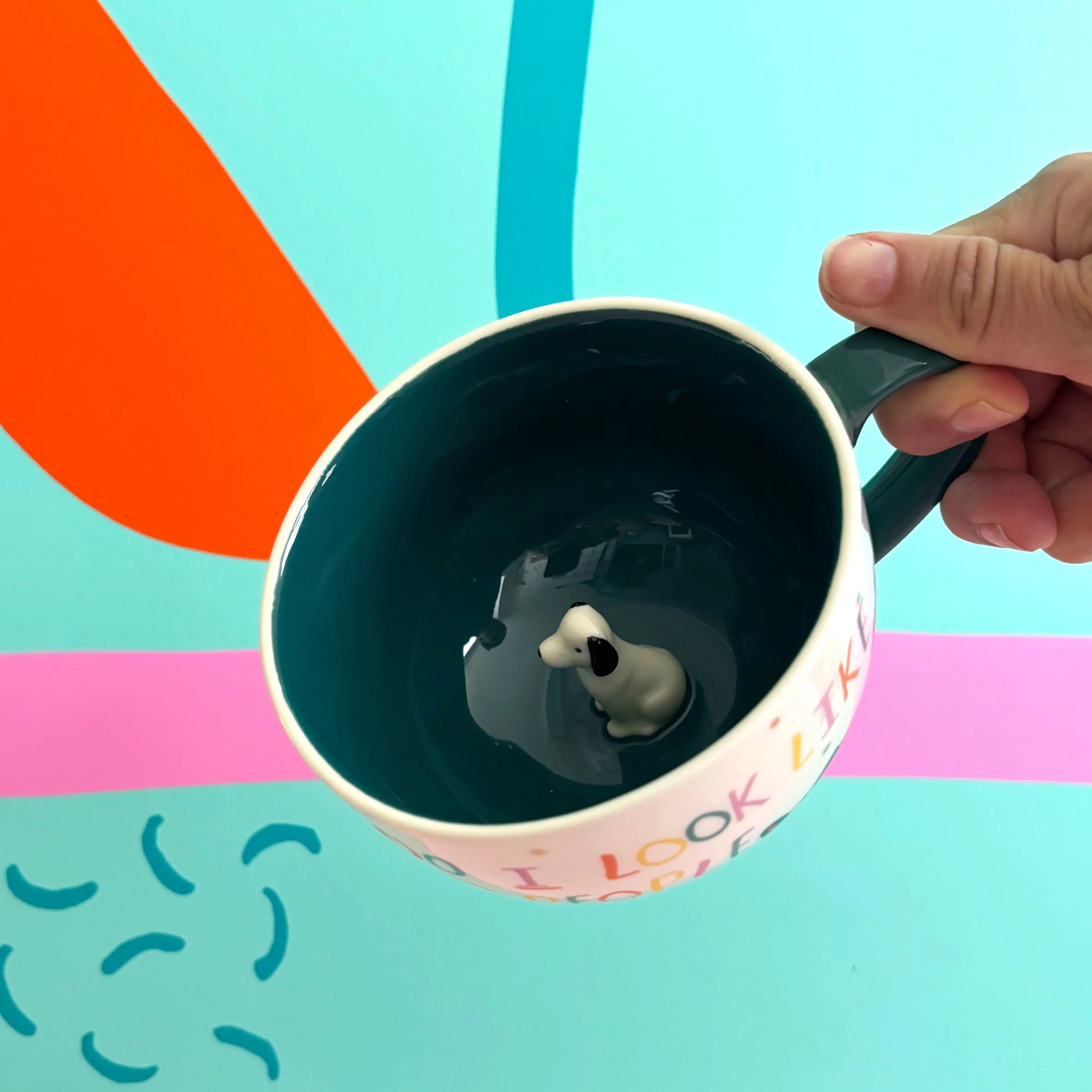 Inside of teal-glazed mug showing hidden 3D ceramic dog.