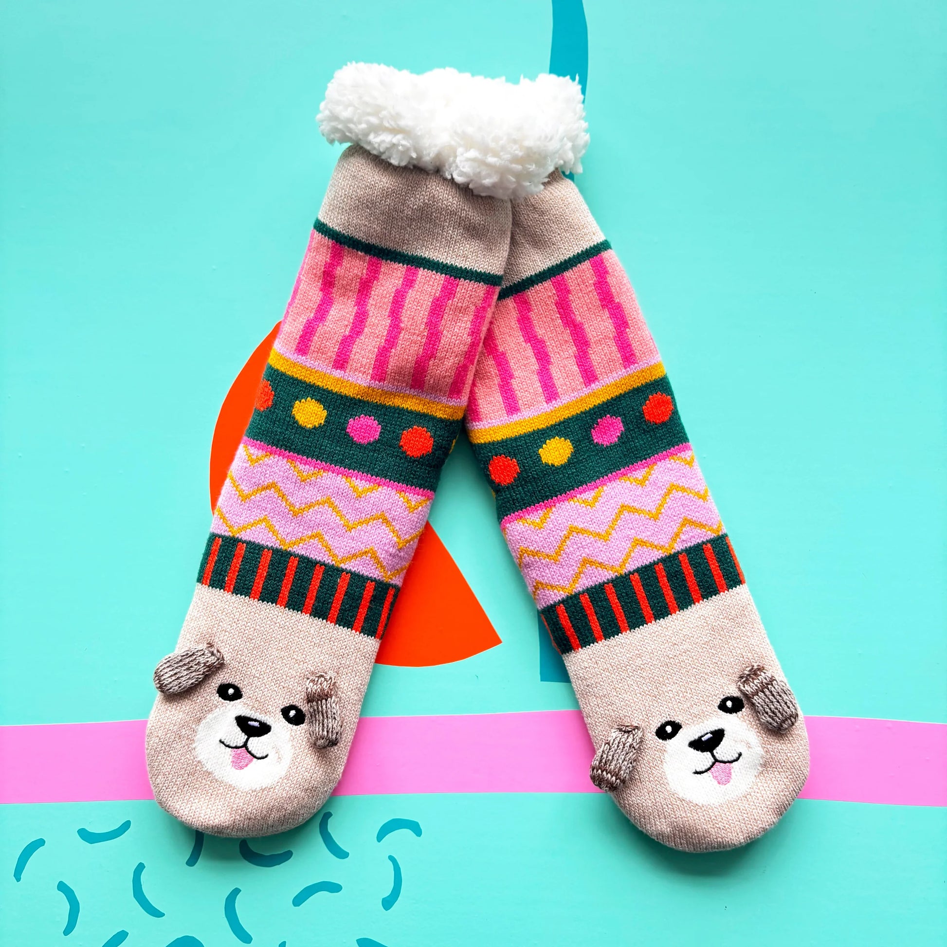 Dog House Slipper Socks with colourful knit pattern and 3D dog faces on bright background.