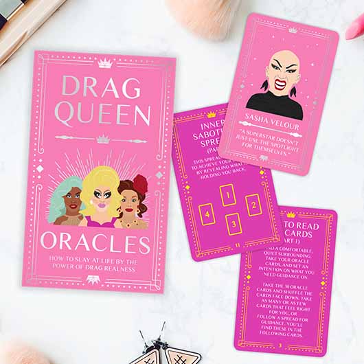 Drag Queen Oracles pink box and cards on marble background.