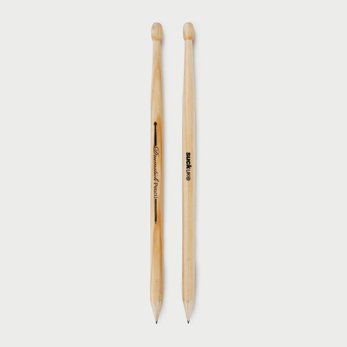 Close-up of two life-size HB wooden pencils shaped like drumsticks, showing SUCK UK branding and natural plywood texture