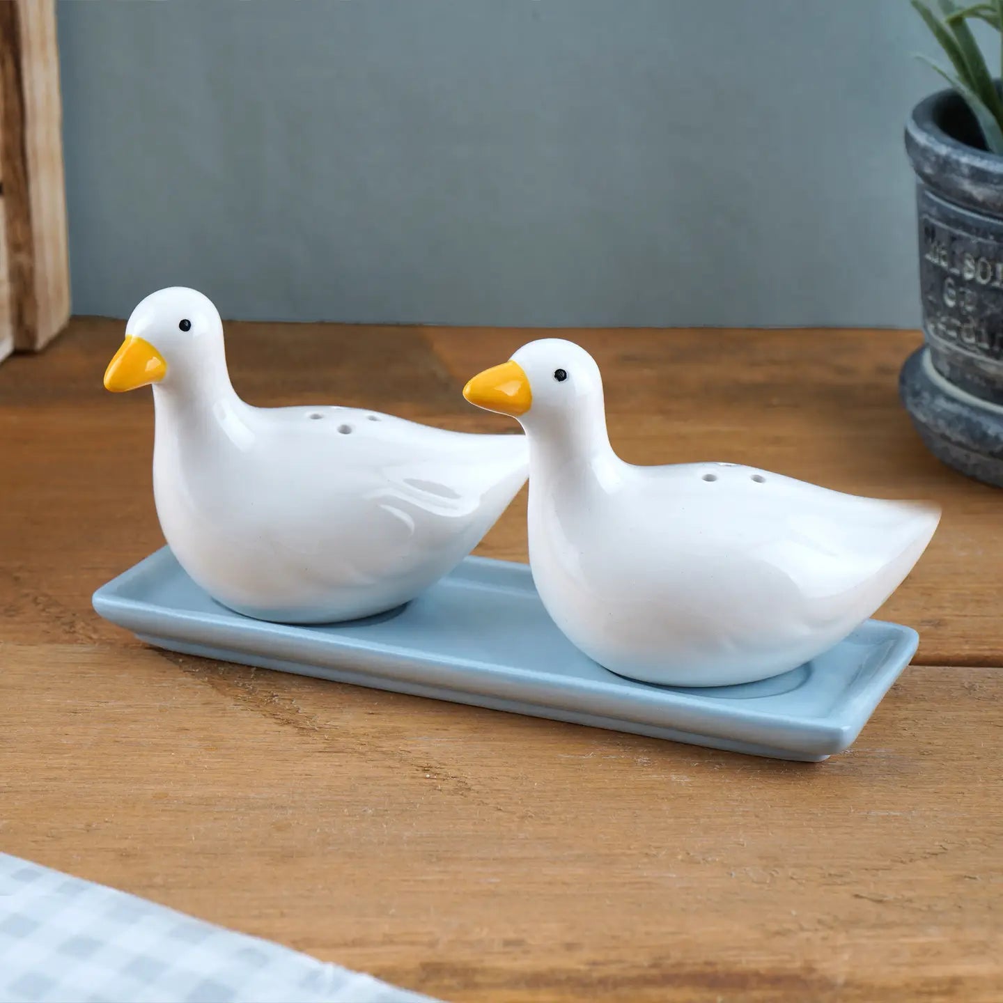 Front view of ceramic duck salt and pepper shakers with hand-painted yellow beaks and subtle grey markings.