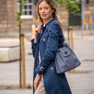 A woman wearing a Navy Earth Squared Juniper Anna Bag, demonstrating its comfortable and stylish design.