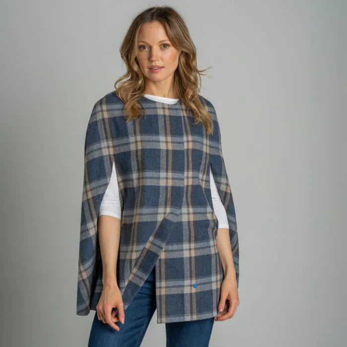 Studio shot of model wearing Earth Squared Tantallon Tweed Cape in navy and beige check.