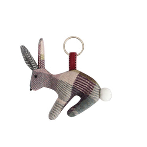 Earth Squared Rabbit Keyring showcasing beautiful Aberlady Tweed in a stunning plum and grey colourway. The rabbit features a fluffy tail, embroidered eyes and whiskers. Attached to a silver keyring with a velour Ribbon.