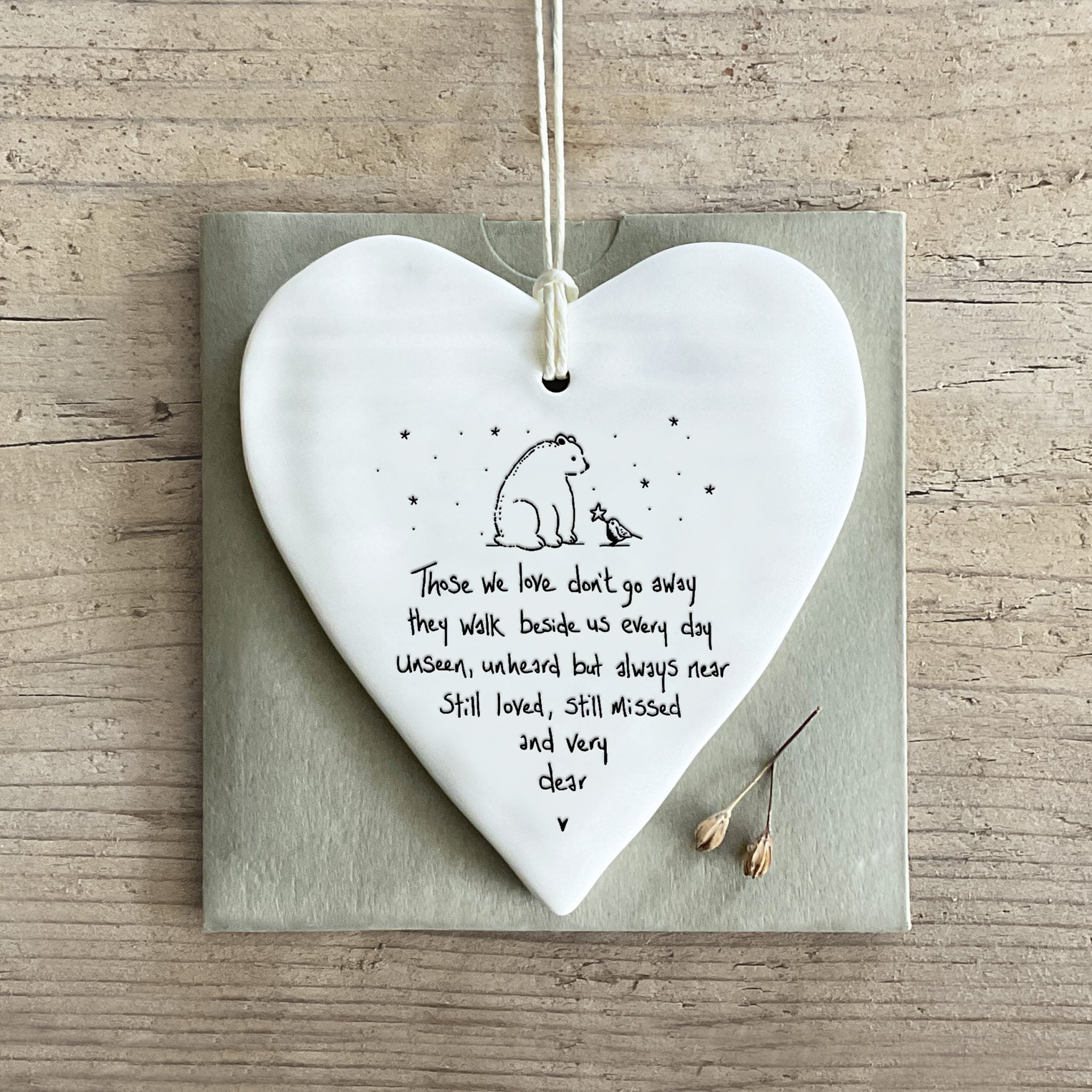 East of India Wobbly Round Heart sympathy keepsake displayed on a wooden surface with a gift card, showing the delicate porcelain texture and heartfelt message.