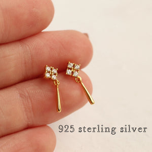 Side angle of gold-plated Edwardian earrings held between fingers, highlighting their delicate size and 925 sterling silver construction