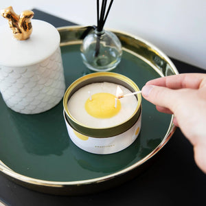 Candle being lit on a green tray with decorative items