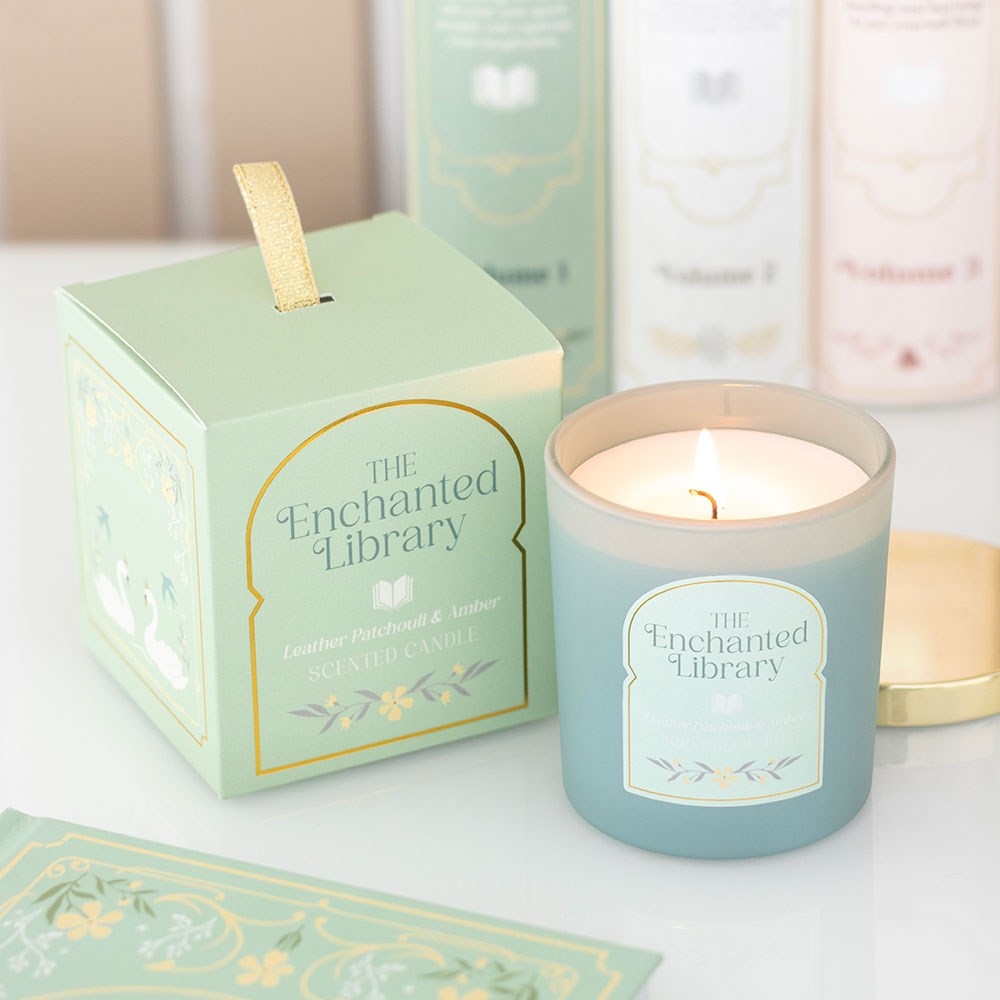 The Enchanted Library candle burning in frosted green jar with gift box – leather, patchouli and amber scent.