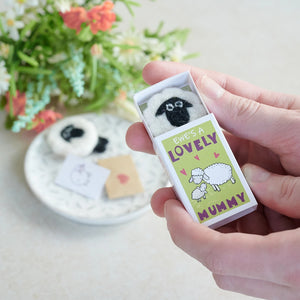 Hand holding “Ewe’s A Lovely Mummy in A Matchbox” gift with a wool felt sheep inside.