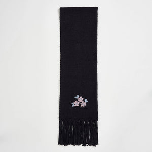 Full-length view of Fable Forget-Me-Not Knitted Navy Scarf with embroidered flowers and tassel trim on a white background.