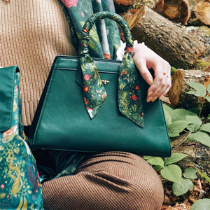 Lifestyle Image – A person holding the Into The Woods tote bag in an outdoor woodland setting, highlighting its storybook-inspired design.