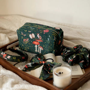 Lifestyle image of the Into the Woods Travel Pouch with matching accessories – The travel pouch styled with matching hair accessories and a candle, creating a cosy, elegant aesthetic.