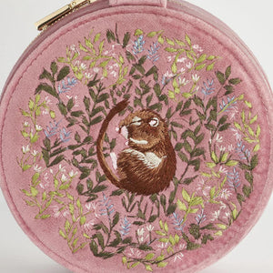 A close-up of the embroidered dormouse sleeping among flowers on the pink jewellery box.