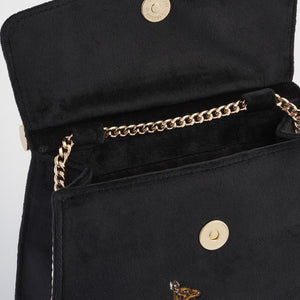 Interior & Closure: An inside view of the bag with its magnetic fastening open, revealing a spacious interior and the neatly tucked gold chain strap.