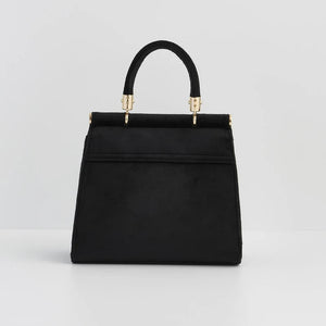 Back View: The black velvet tote from the back, showing its smooth, unembellished surface and structured silhouette.