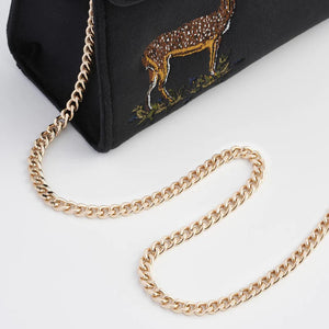 Gold Chain Detail: A close-up of the detachable gold chain strap draped over the side of the bag, showing its elegant finish and versatility.