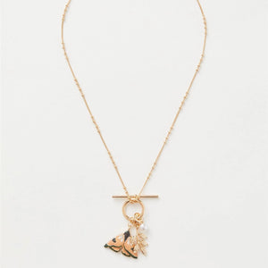 Full view of the T-bar necklace with the enamel moth charm and delicate gold-plated chain.