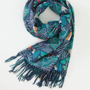 A beautifully folded Fable England The Enchanted Tree Scarf in navy, showcasing its detailed woodland print and delicate fringe.