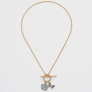 Flat-lay image of the necklace with its toggle clasp and intricate enamel-painted charms.