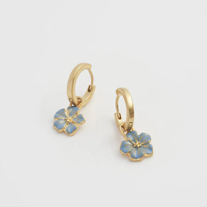 Angled side view of the earrings – showcasing the delicate hand-painted details of the forget-me-not charms.