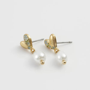 Flat Lay View – Earrings positioned on a white background, highlighting the gold-tone details and soft pearl hue.