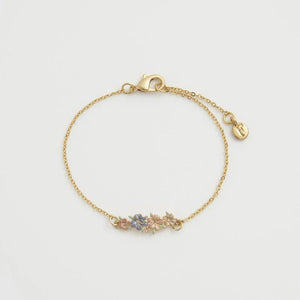 Close-up of the Fable England Hibiscus Bracelet, showcasing hand-painted floral details on a gold-plated chain.