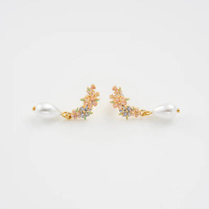 Flat lay of the earrings, displaying the beautiful floral pattern and pearl drop design.