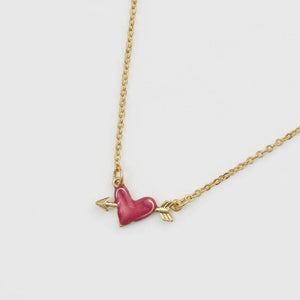 A close-up of the Fable England Lovestruck Heart Necklace, featuring a red enamel heart pierced by a golden arrow on a delicate gold chain.