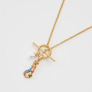 Close-up of gold Peter Rabbit enamel charm necklace with faux pearl detail.