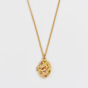 Close-up of Robin & Blackberry Gold Oval Locket Necklace on gold chain with enamel bird and berry design.