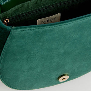 Inside of Robin Love green velvet embroidered saddle bag showing magnetic fastening and lined compartment.