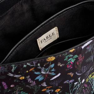 Interior view of Fable England Wilderness Backpack with black lining and visible branded label above internal compartments.