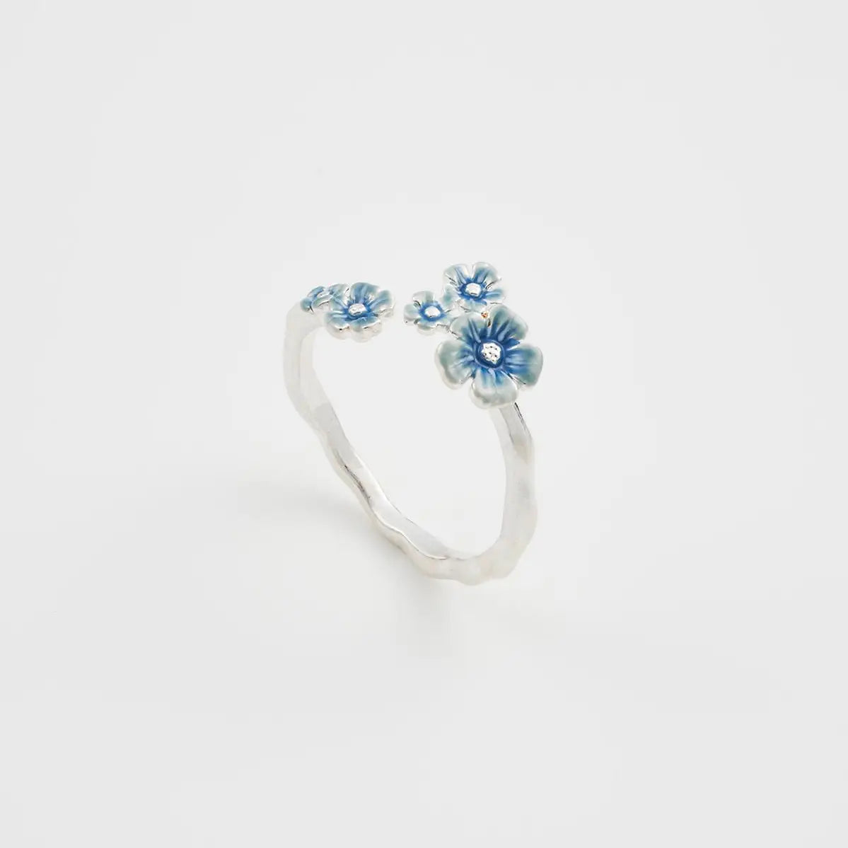 Front view of Fable Forget Me Not silver ring with hand-painted blue enamel flowers on a twig-style band.