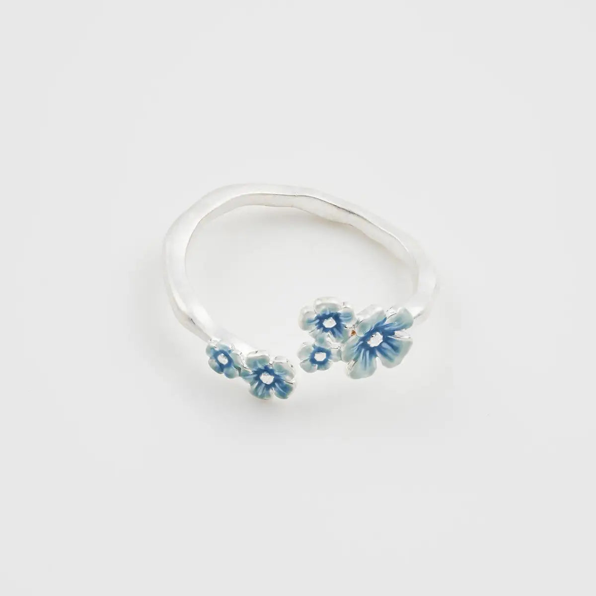 Top view of silver-plated Forget Me Not ring featuring delicate enamel blossoms in varying sizes.