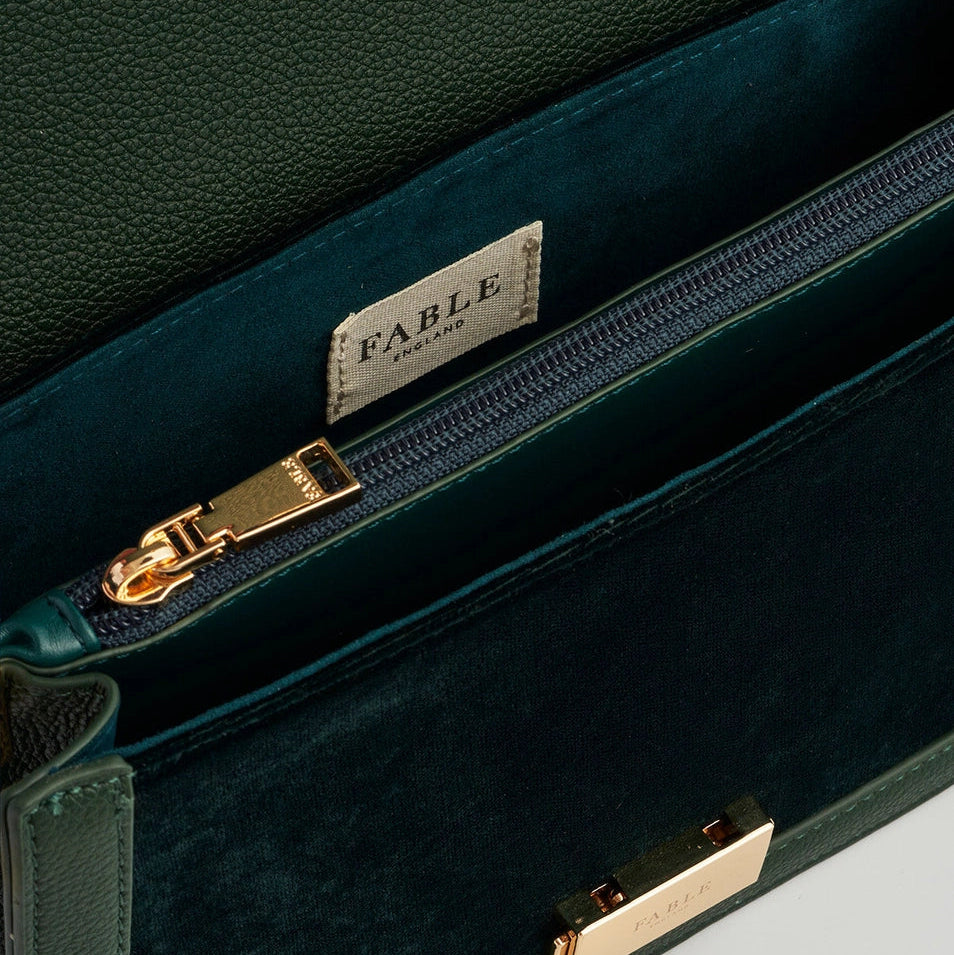 Interior view of Fawn Embroidered Green Crossbody Bag showing gold zip, Fable label, and lined compartments.