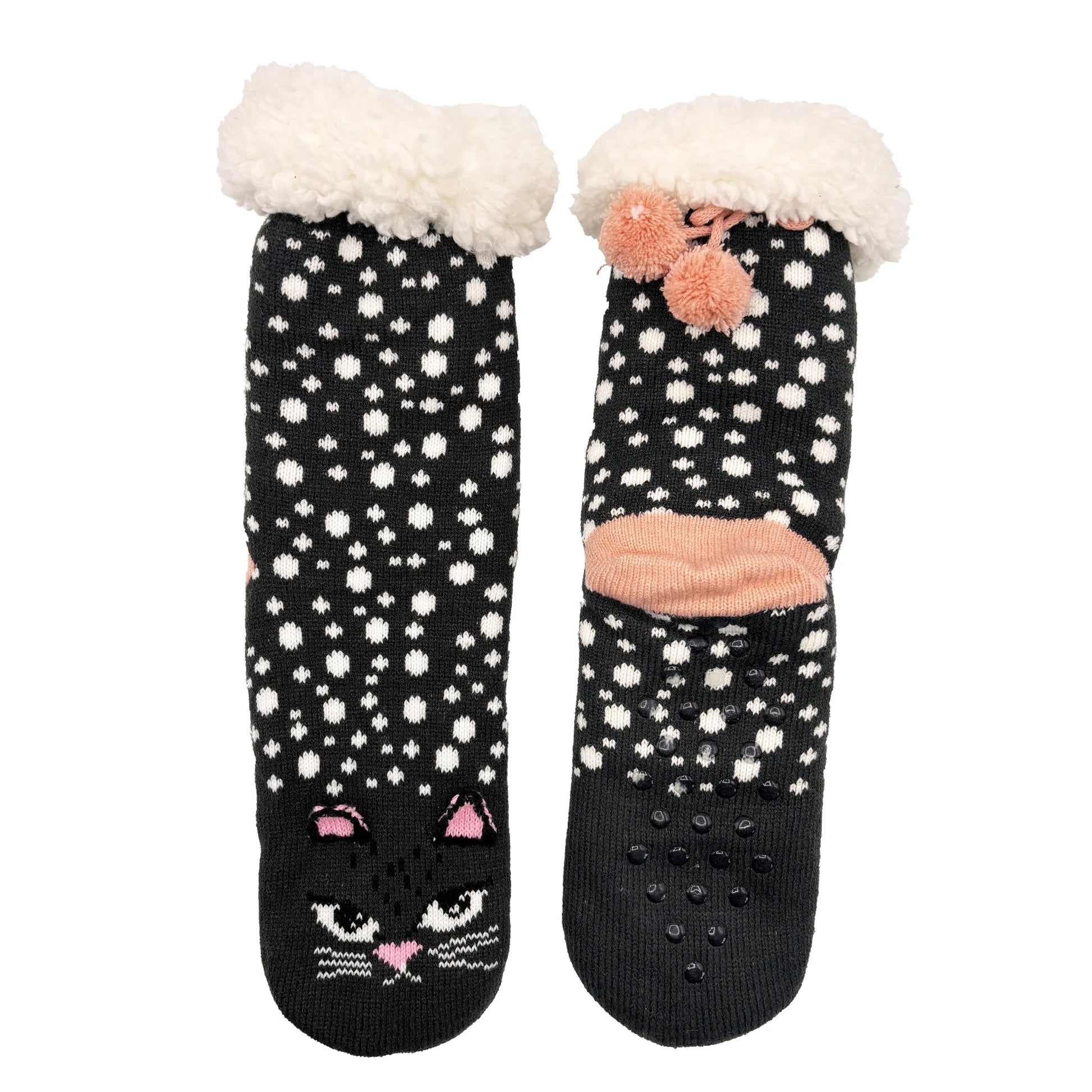 Flat lay of black and white polka dot slipper socks with pink accents.