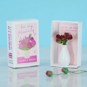 A close-up of the opened matchbox, revealing a mini ceramic vase with tiny pink roses and the message “You’re the pick of the bunch!”