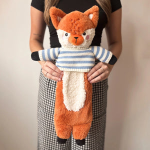 Person holding soft fox hot water bottle with cosy knitted jumper.