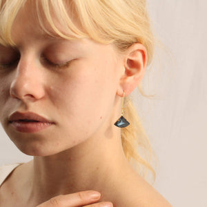 A close-up of a model wearing the French Navy Art Deco earrings, showcasing their elegant fan-shaped design and gold-plated ear wires.