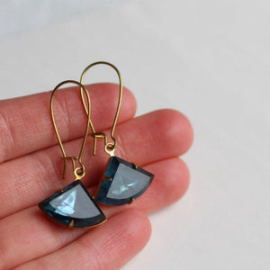 A pair of French Navy Art Deco earrings displayed on a hand, highlighting their deep navy blue glass jewels and classic vintage-inspired design.